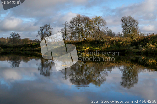 Image of Autumn landscape with colorful trees and river. Reflection in ri