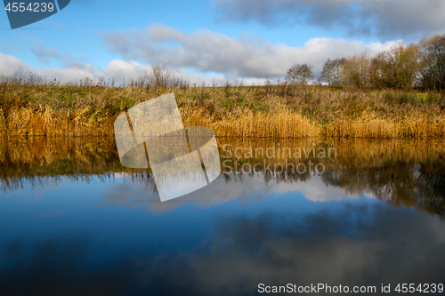 Image of Autumn landscape with colorful trees and river. Reflection in ri