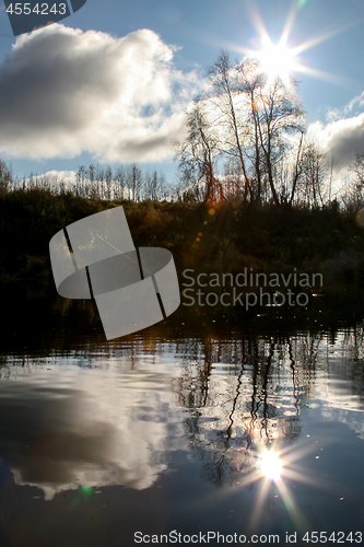 Image of Autumn landscape with colorful trees and river. Evening reflecti