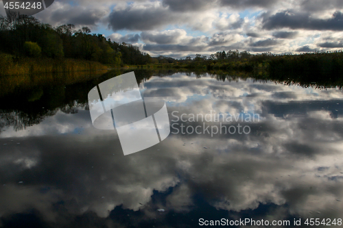 Image of Autumn landscape with colorful trees, grass and river. Reflectio