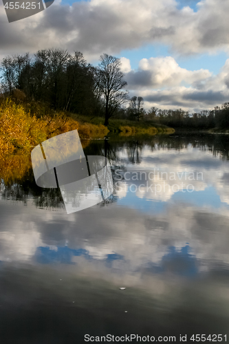 Image of Autumn landscape with colorful trees, yellow grass and river. Re