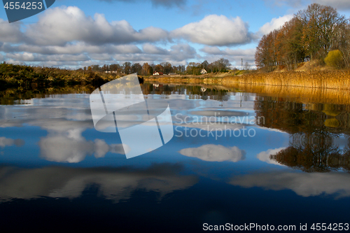 Image of Autumn landscape with colorful trees, yellow grass and river. Re