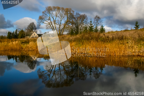 Image of Autumn landscape with colorful trees, yellow grass and river. Re