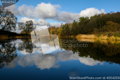 Image of Autumn landscape with colorful trees, yellow grass and river. Re