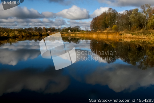 Image of Autumn landscape with colorful trees, yellow grass and river. Re