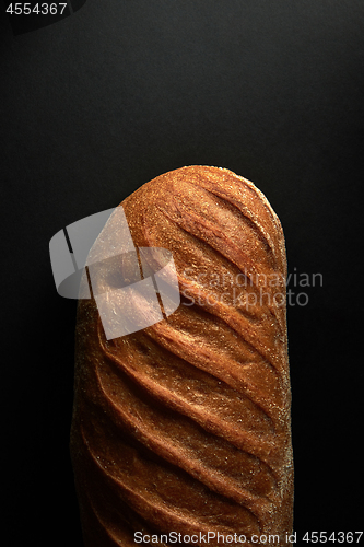 Image of Freshly baked healthy white bread on a black background with copy space. Top view