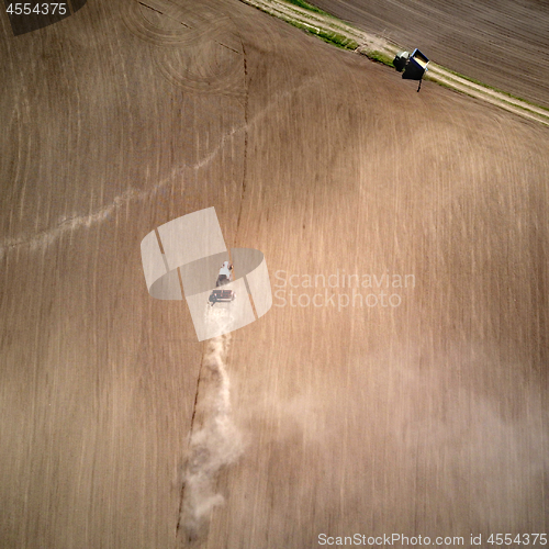 Image of Aerial view tractor with a cultivator for seeds at the beginning of the spring season of agricultural work