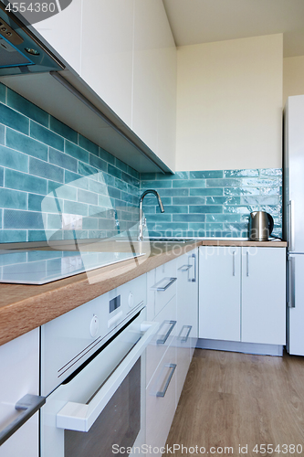 Image of White glossy kitchen with modern appliances