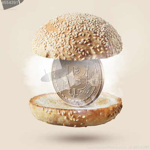 Image of Burger with gold coin bitcoin on beige background