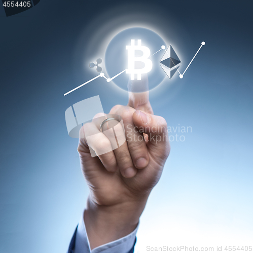 Image of the man clicks Icon Bitcoin on virtual screen.