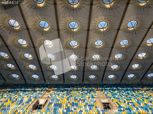 Image of KYIV, UKRAINE - July 19, 2018. Elements of roof construction the stadium NSC Olimpiysky with empty tribunes in blue and yellow colors before the game.