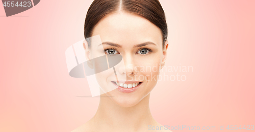 Image of face of beautiful woman over pink background