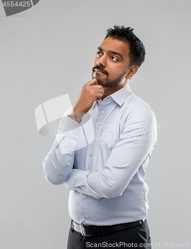 Image of indian businessman thinking over grey background