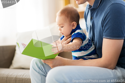 Image of baby boy and father with book at home