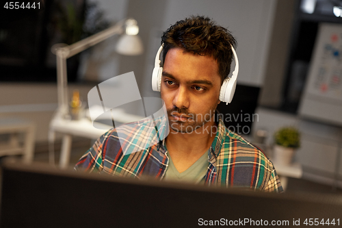 Image of creative man with headphones working at office