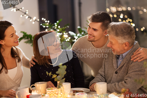 Image of happy family having tea party at home
