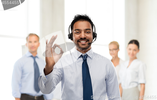 Image of businessman or helpline operator showing ok sign