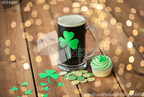 Image of shamrock on glass of beer, green cupcake and coins