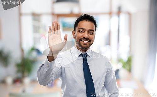 Image of businessman making high five gesture at office