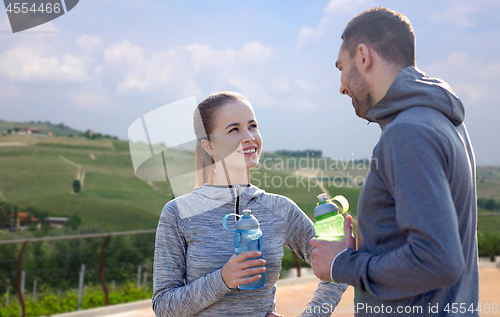 Image of couple with bottles of water after sports outdoors