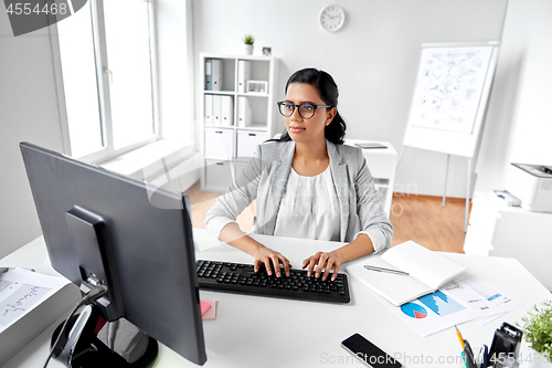 Image of businesswoman with computer working at office