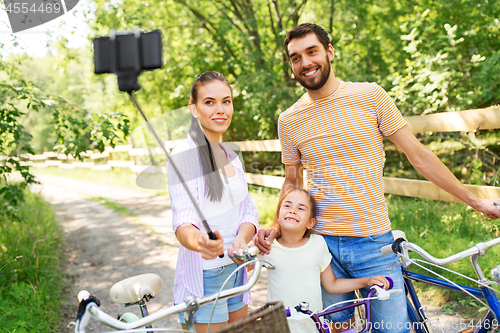 Image of happy family with bicycles taking selfie in summer