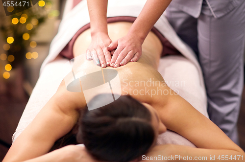 Image of woman having back massage with gel at spa