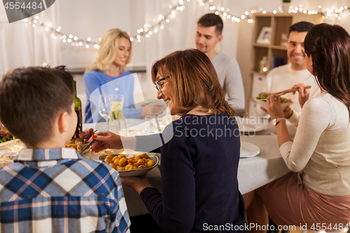 Image of happy family having dinner party at home