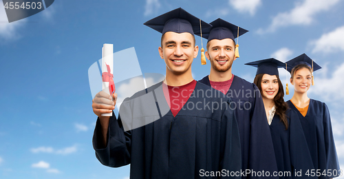 Image of graduates in mortar boards with diploma