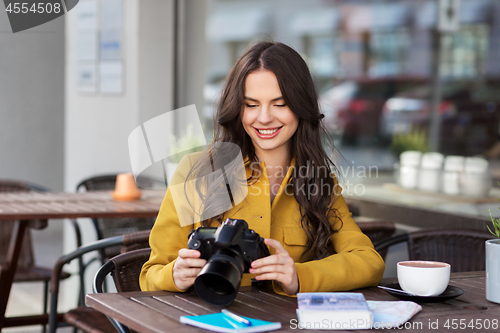 Image of tourist or teenage girl with camera at city cafe