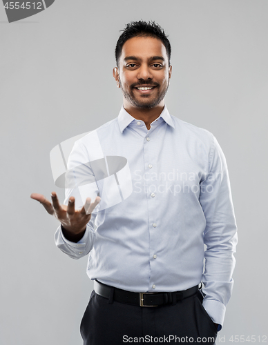 Image of indian businessman holding something invisible
