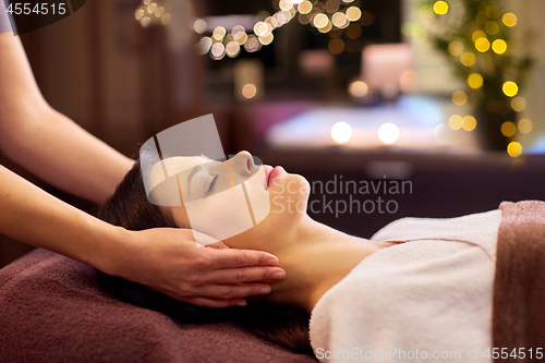 Image of woman having face and head massage at spa