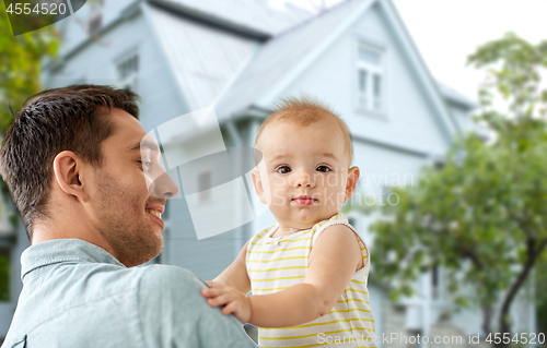 Image of father with little baby daughter over house