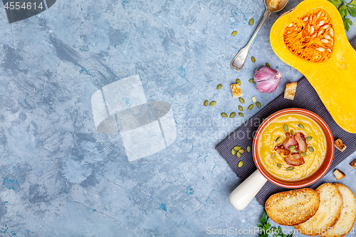 Image of Homemade autumn hot pumpkin soup with bacon and seeds.