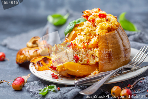 Image of Sliced pumpkin stuffed with couscous and vegetables.