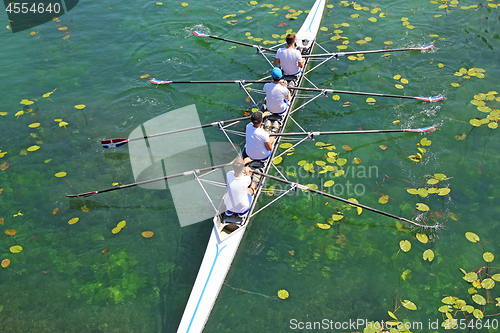 Image of Men's quadruple rowing team on green water