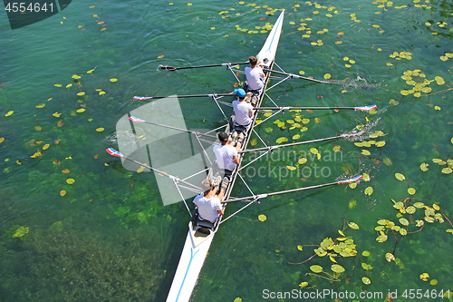 Image of Men's quadruple rowing team on green water