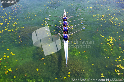 Image of Men's quadruple rowing team on green water