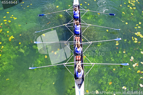 Image of Men's quadruple rowing team on green water