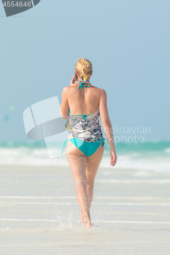 Image of Happy woman having fun, enjoying summer, walking joyfully on tropical beach, Zanzibar, Tanzania.