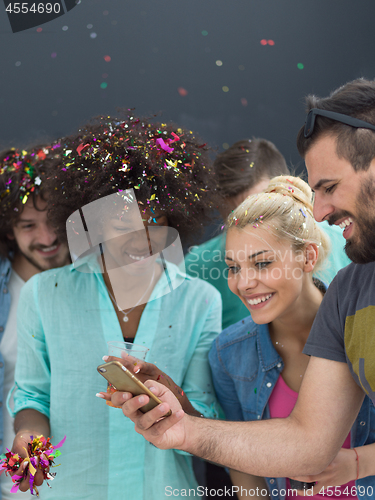 Image of confetti party multiethnic group of people isolated over gray