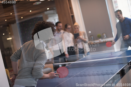 Image of startup business team playing ping pong tennis