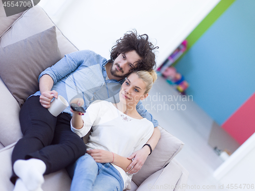 Image of Young couple on the sofa watching television