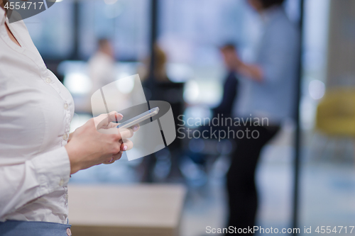 Image of Elegant Woman Using Mobile Phone in startup office building