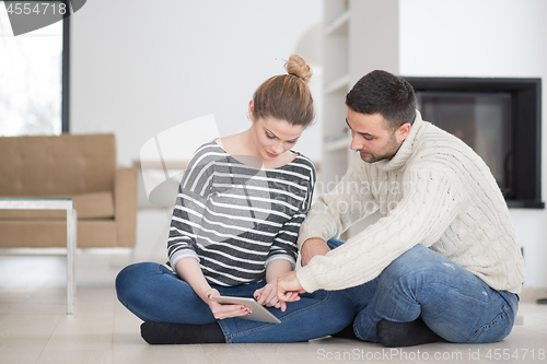 Image of Young Couple using digital tablet on cold winter day