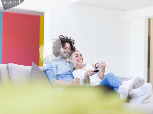 Image of Young couple on the sofa watching television