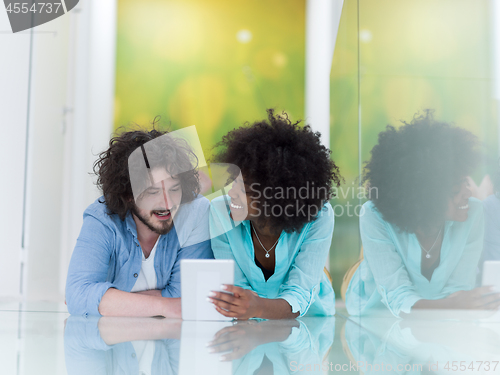 Image of Couple relaxing together at home with tablet computer