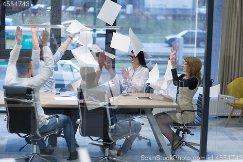 Image of startup Group of young business people throwing documents