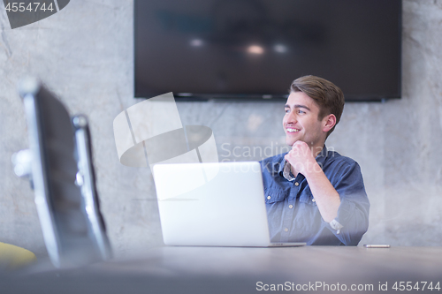 Image of businessman working using a laptop in startup office