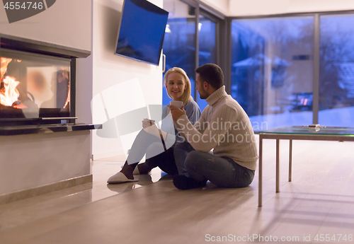 Image of happy couple in front of fireplace